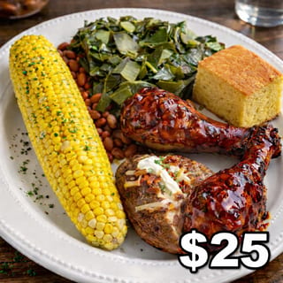 BBQ chicken plate with collard greens, baked beans, corn on the cob, loaded baked potato, and dinner